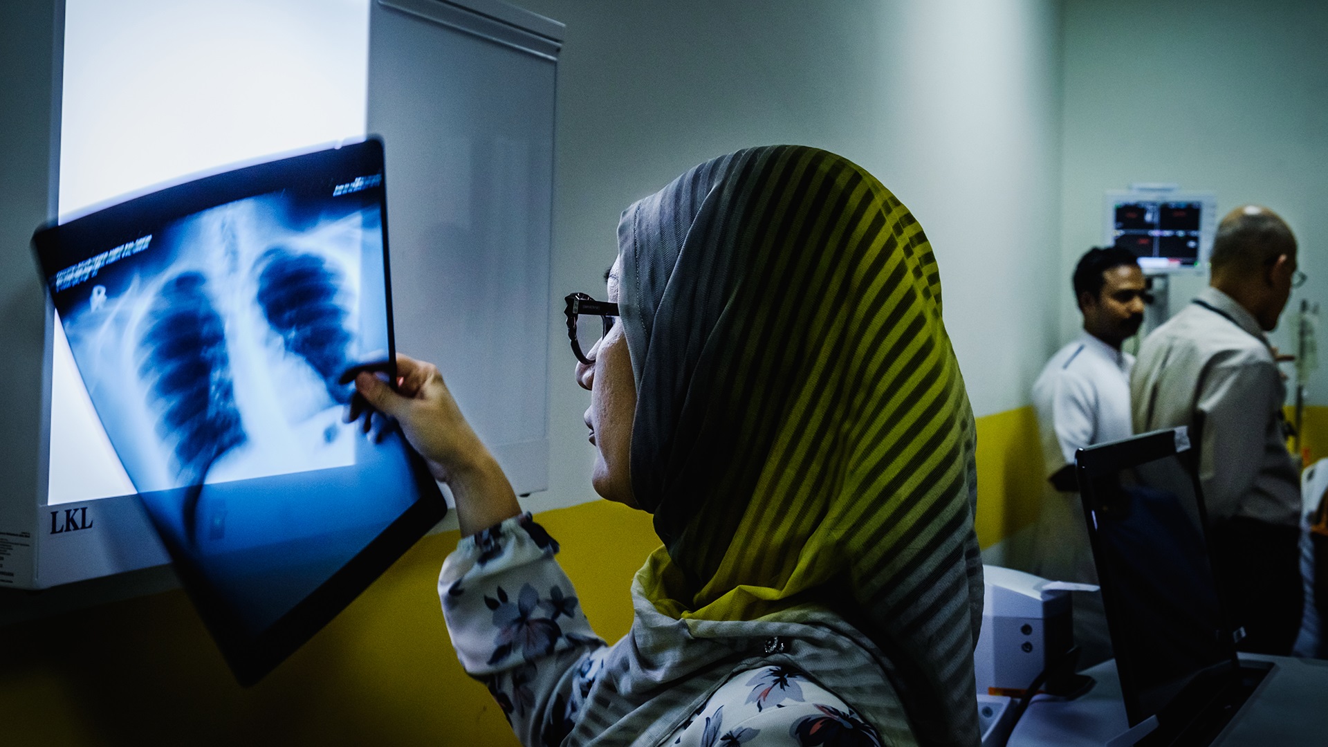 Photo 3 Photo of a woman holding an X-ray in her hand in an exam room at a hospital in Bandar Seri Begawan, Brunei Darussalam.