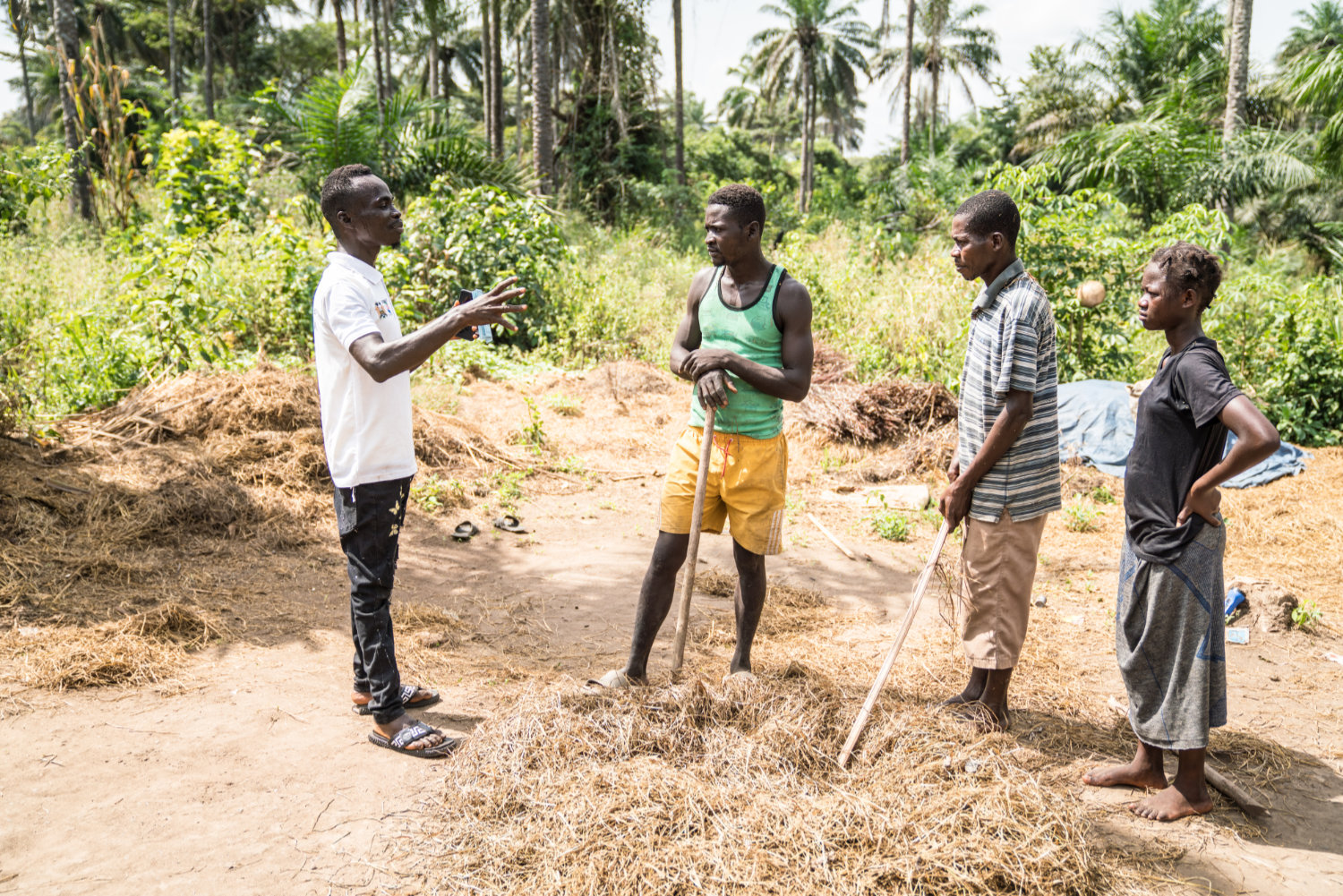 WHO01294_credit-WHO-MichaelDuff_small Community mobiliser Jeremiah (left) speaks with rice farmers in Sierra Leone