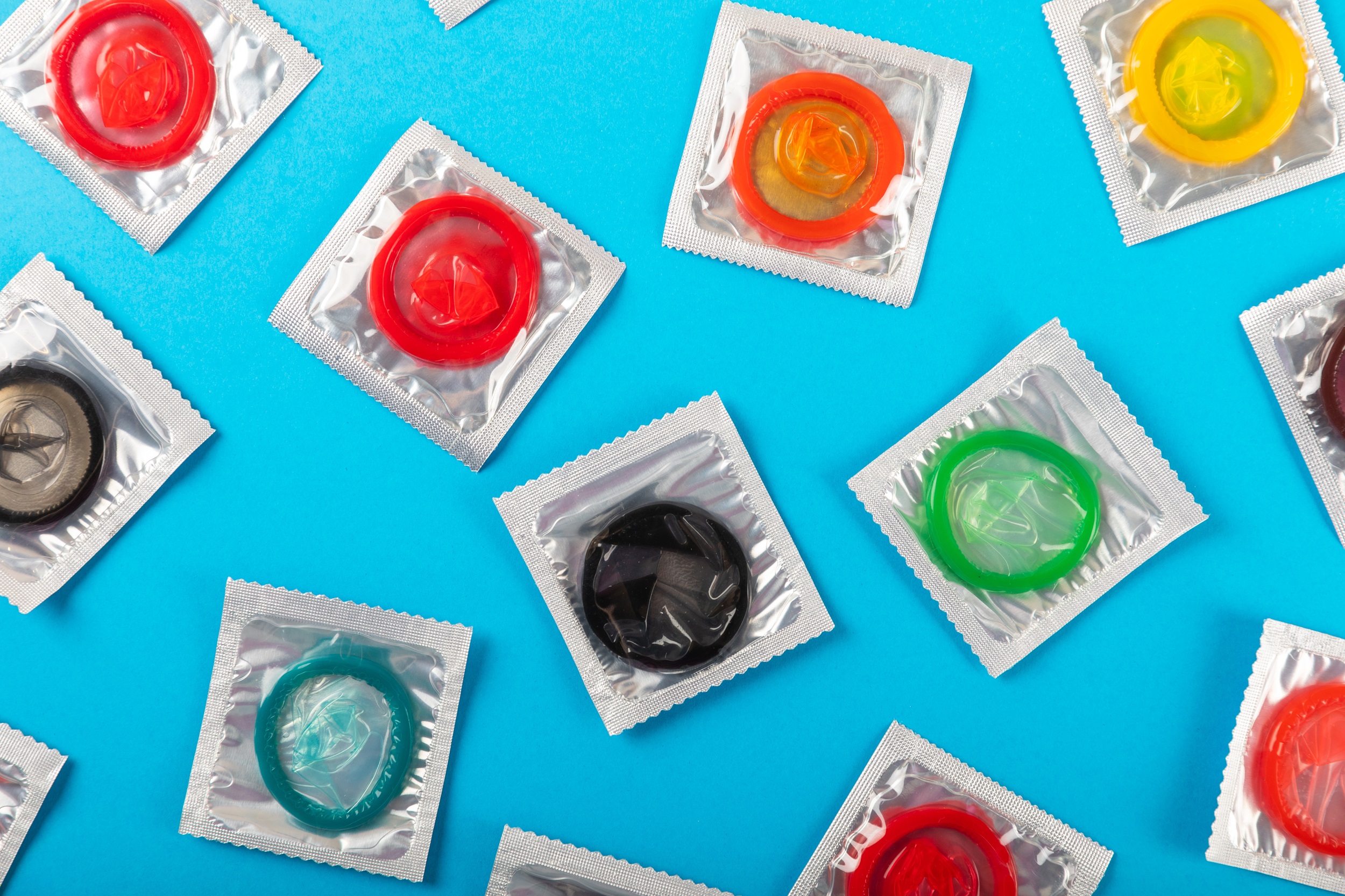 shutterstock_2133438337 Packages of condoms in different colours.