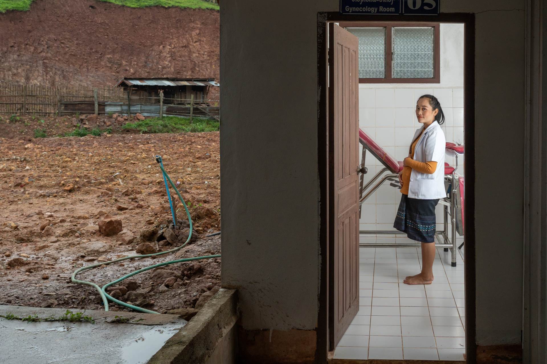 DSC08706-2 A pregnant nurse stands in a doorway at a clinic