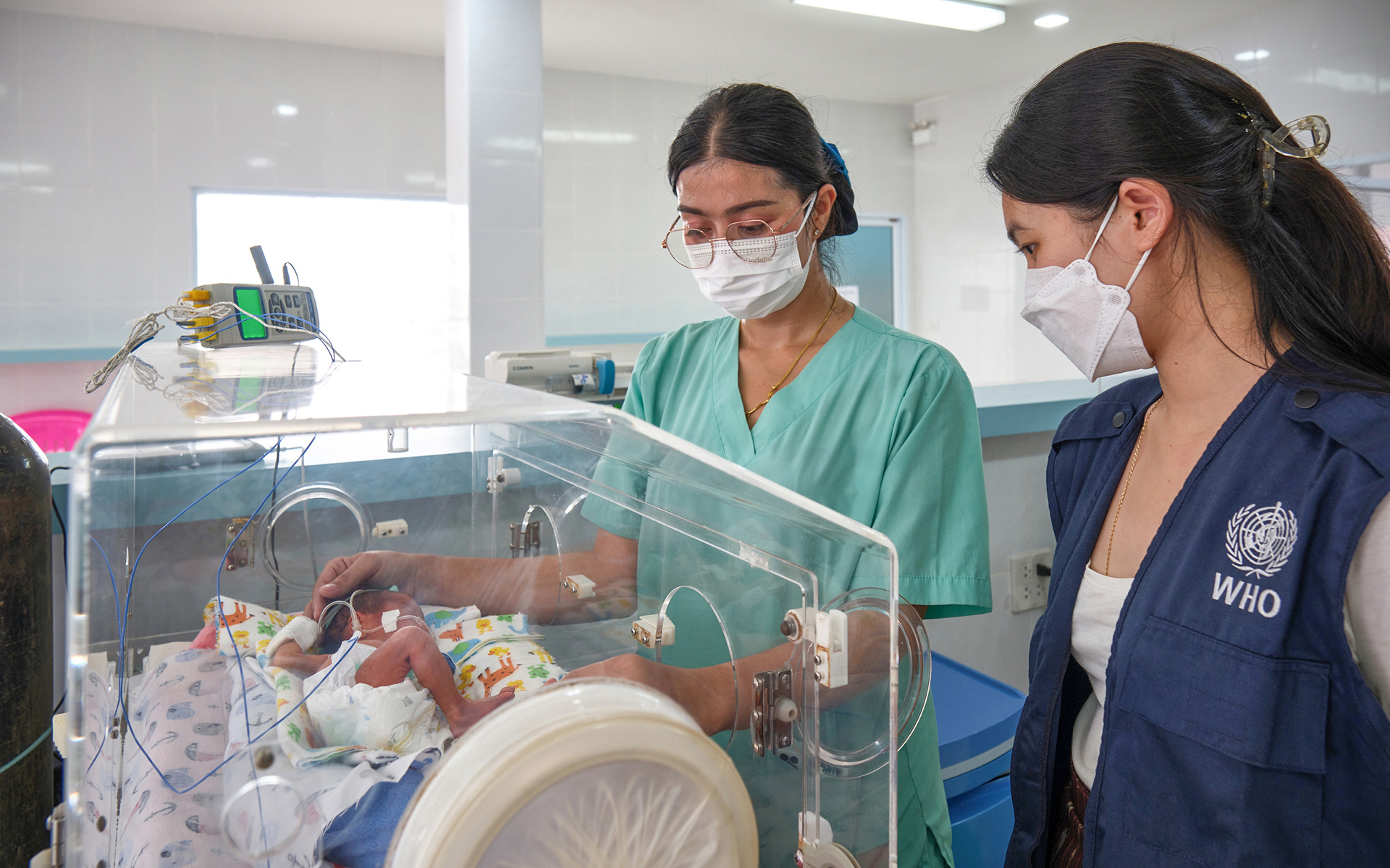 _XH22122 WHO staff and hospital staff checks on the infant in an incubator