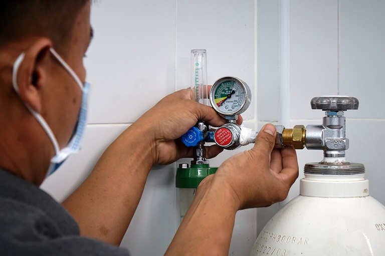 _XH22311 Staff checking the oxygen regulator